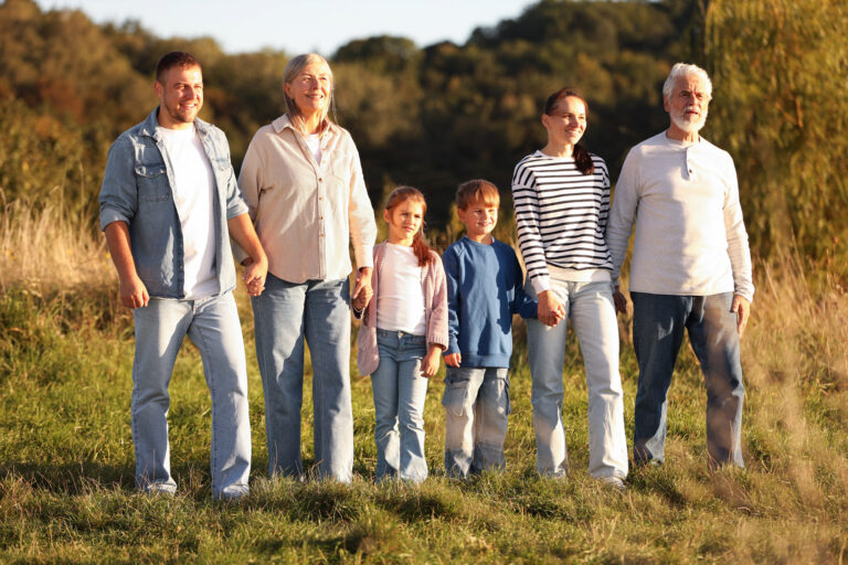 Mehrere Generationen einer Familie stehen auf einer Wiese
