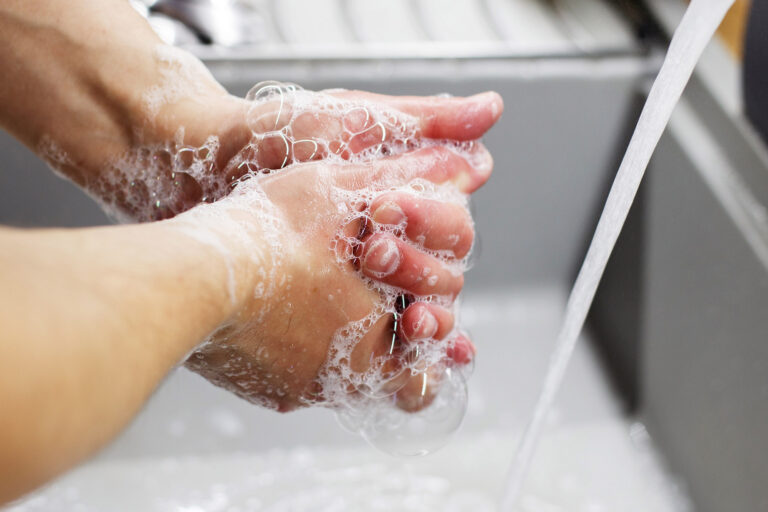 Hände werden unter fließendem Wasser gewaschen