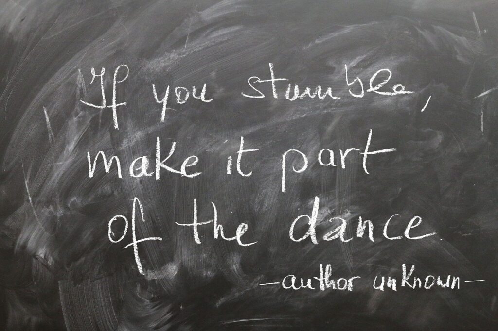 Tafel mit der handgeschriebenen Botschaft: 'If you stumble, make it part of the dance' – ein ermutigendes Zitat über den Umgang mit Herausforderungen.