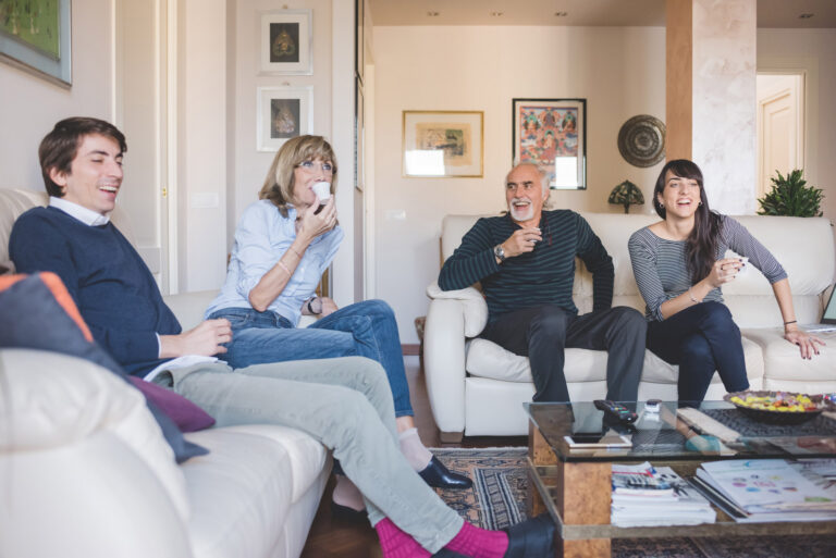 Menschen sitzen im Kreis auf Sofas und sprechen miteinander