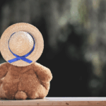 Rückansicht eines Teddybären mit Strohhut – Symbol für Einsamkeit oder Kindheitserinnerungen