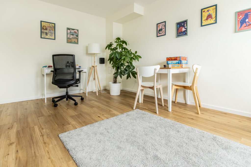 Behandlungsraum für Kinder und Jugendliche mit Schreibtisch, Spieltisch und Dinosaurier-Bildern